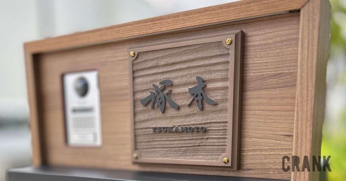 木目調の板に浮き彫りで仕上げた自筆文字の表札、設置後の写真