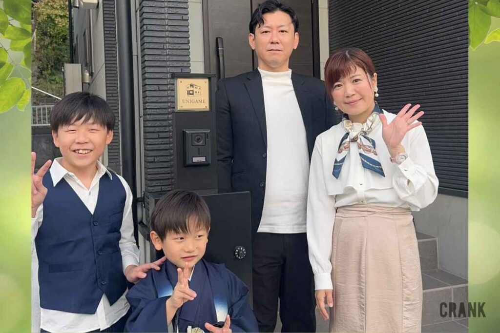 七五三の着物姿の子供たちと笑顔の雲丹亀様ご一家が新居の玄関でCRANKの外観表札を囲んで立つ様子