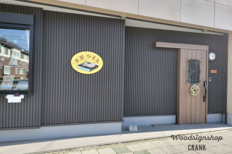 静岡市葵区「本屋ひるね」様の外壁に設置された楕円形の木製店舗看板と玄関横の木製表札。